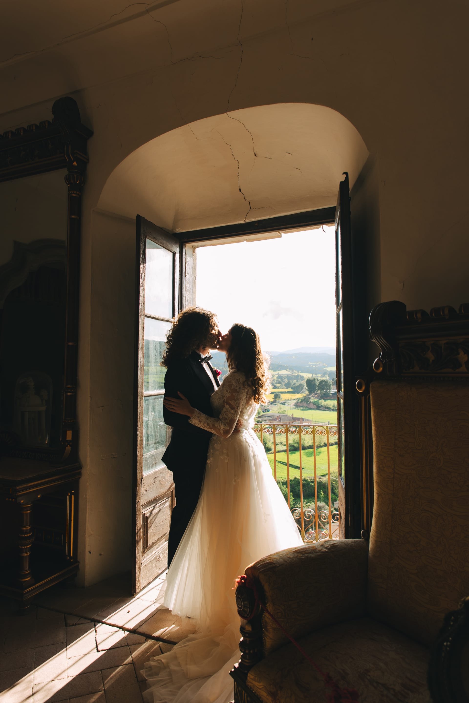 Un beso en el ventanal del castillo, con el campo abierto detrás