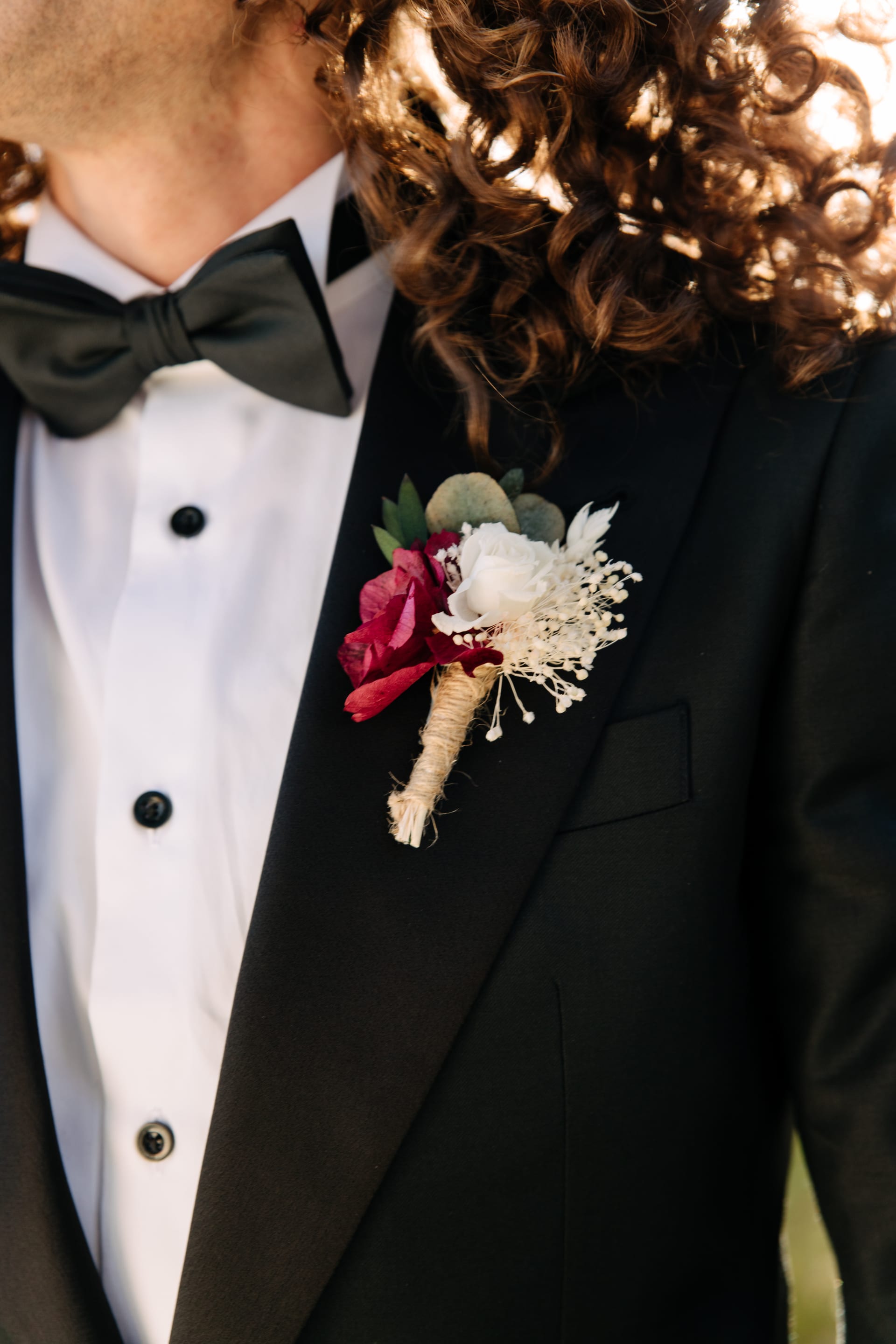 Detalle de la pajarita y la flor de solapa del esmoquin
