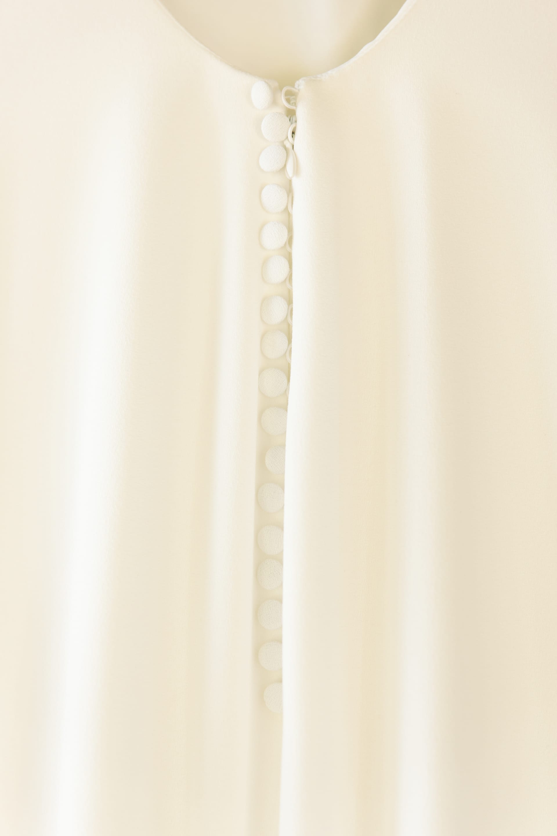 Detalle de la hilera de botones forrados de la espalda del vestido de la novia