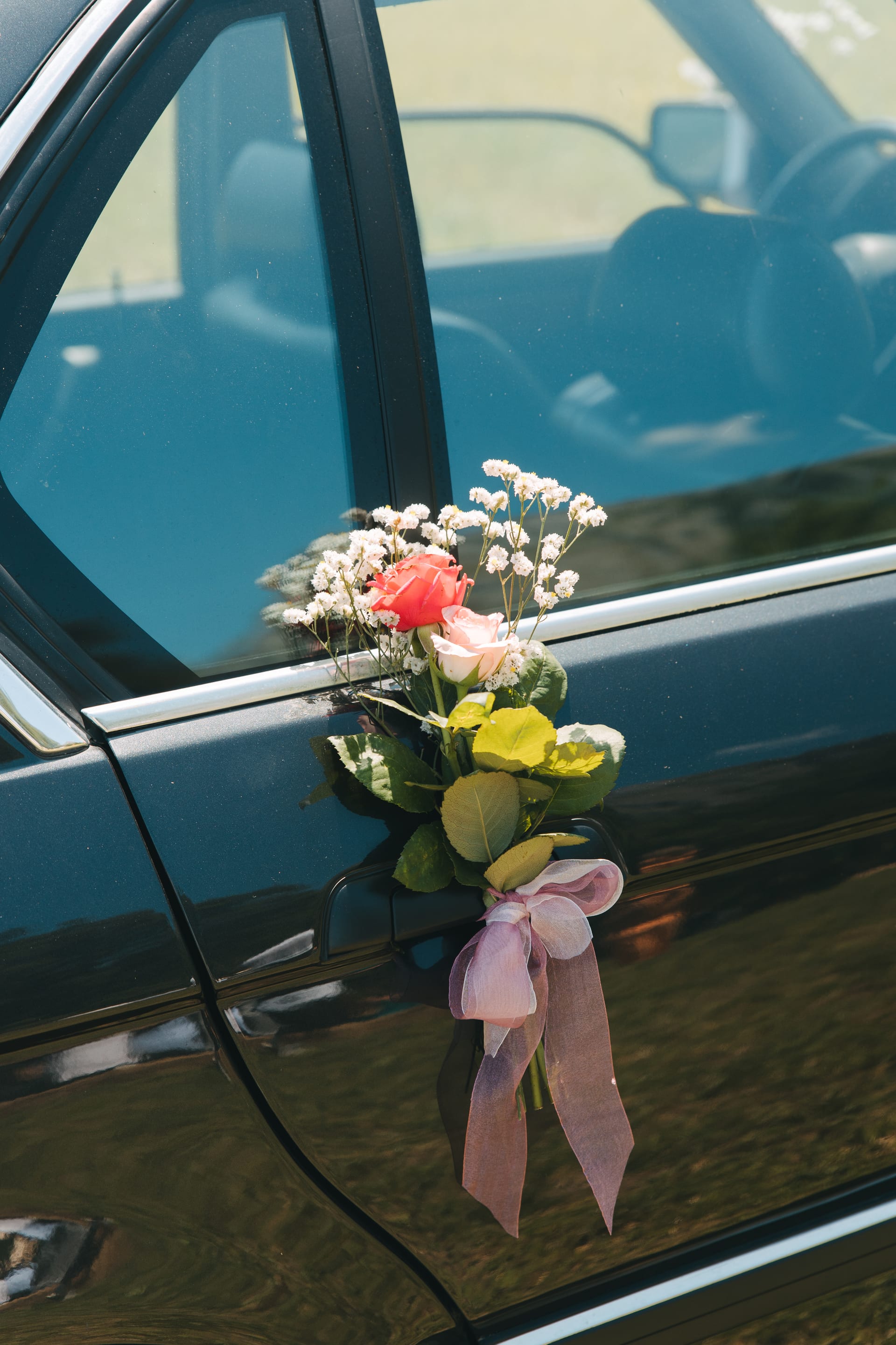 Flores y cintas atadas a la puerta de un coche