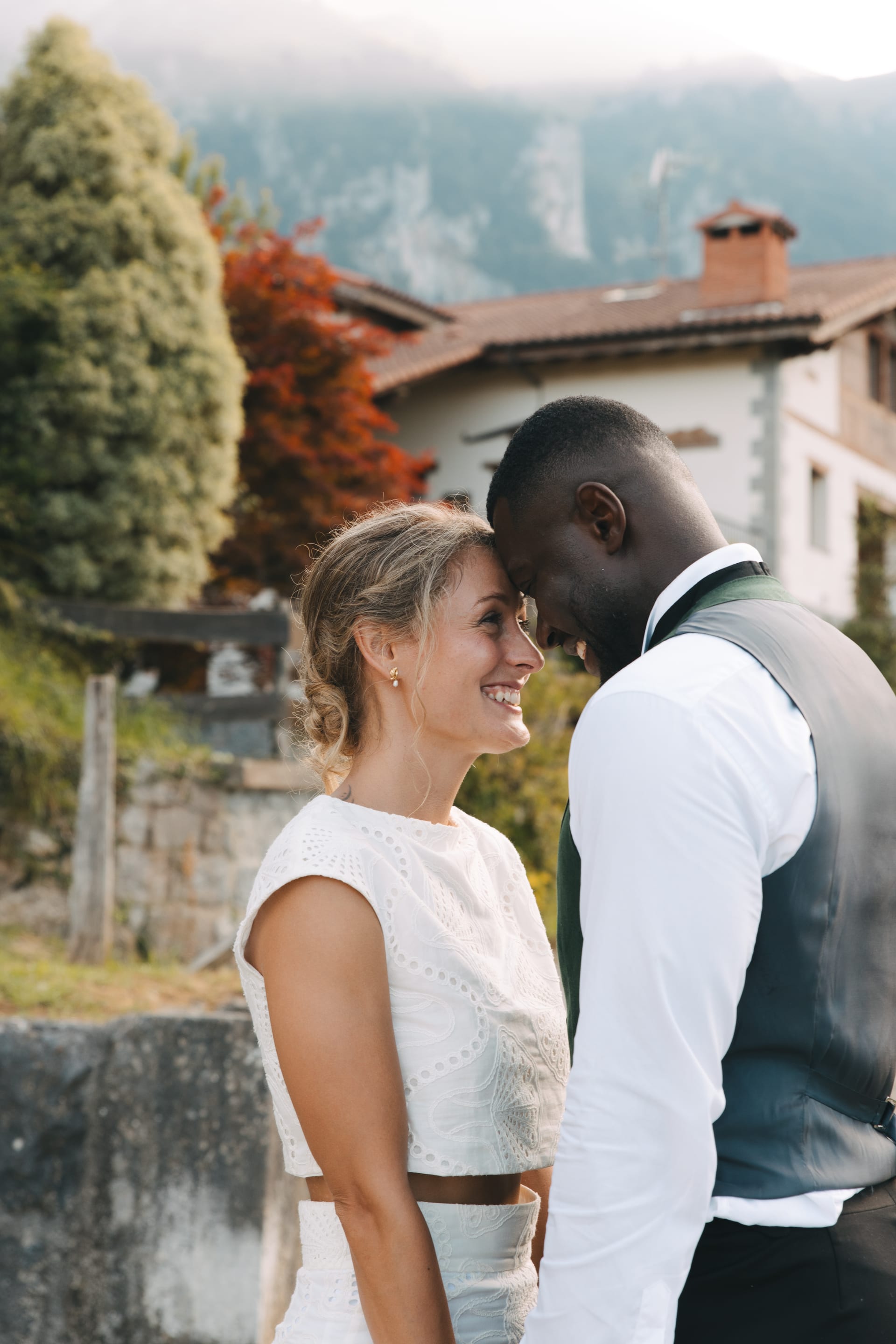 Los novios muy cerca sonriendo, con el pueblo detrás