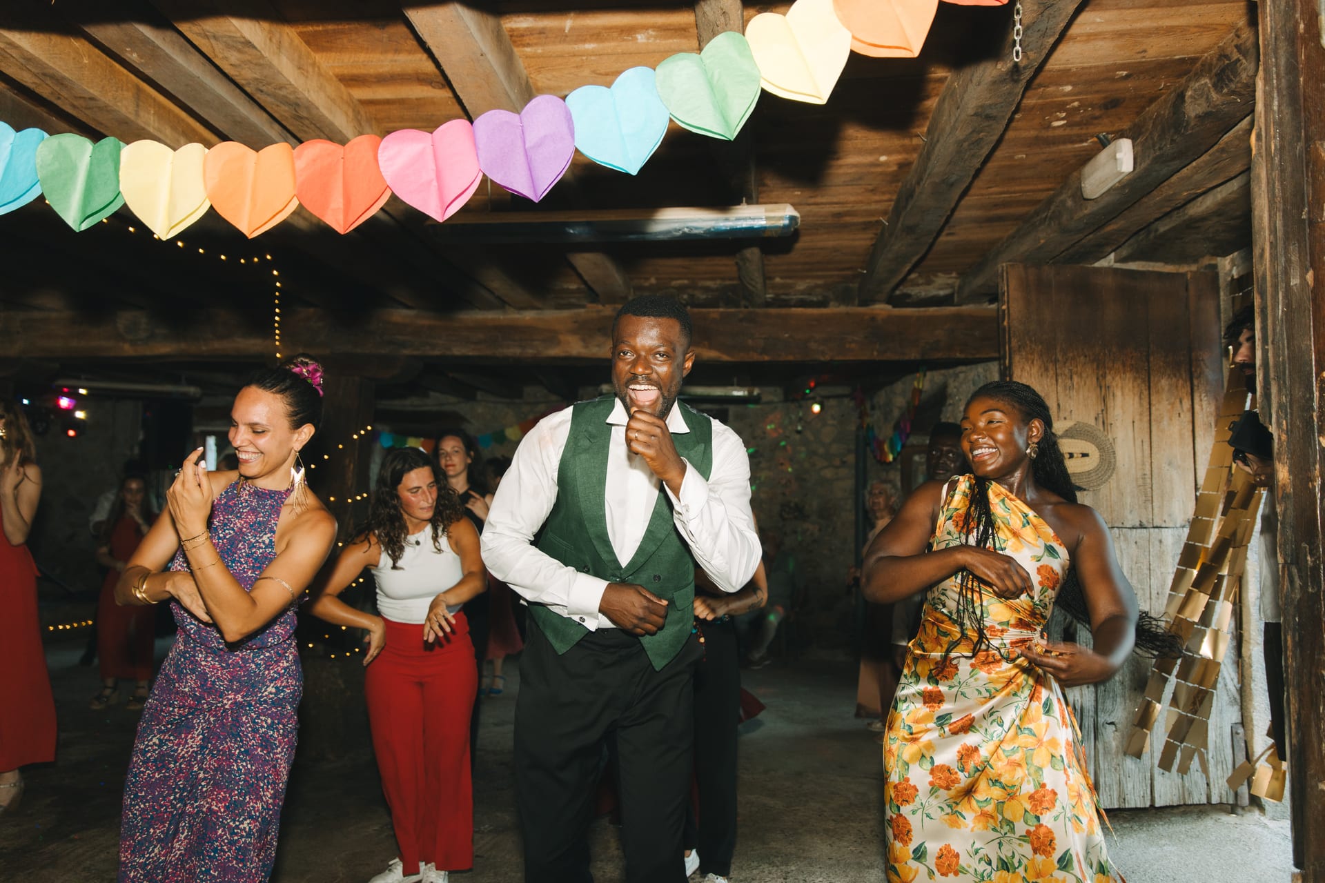 Baile bajo guirnaldas de corazones de papel y vigas de madera